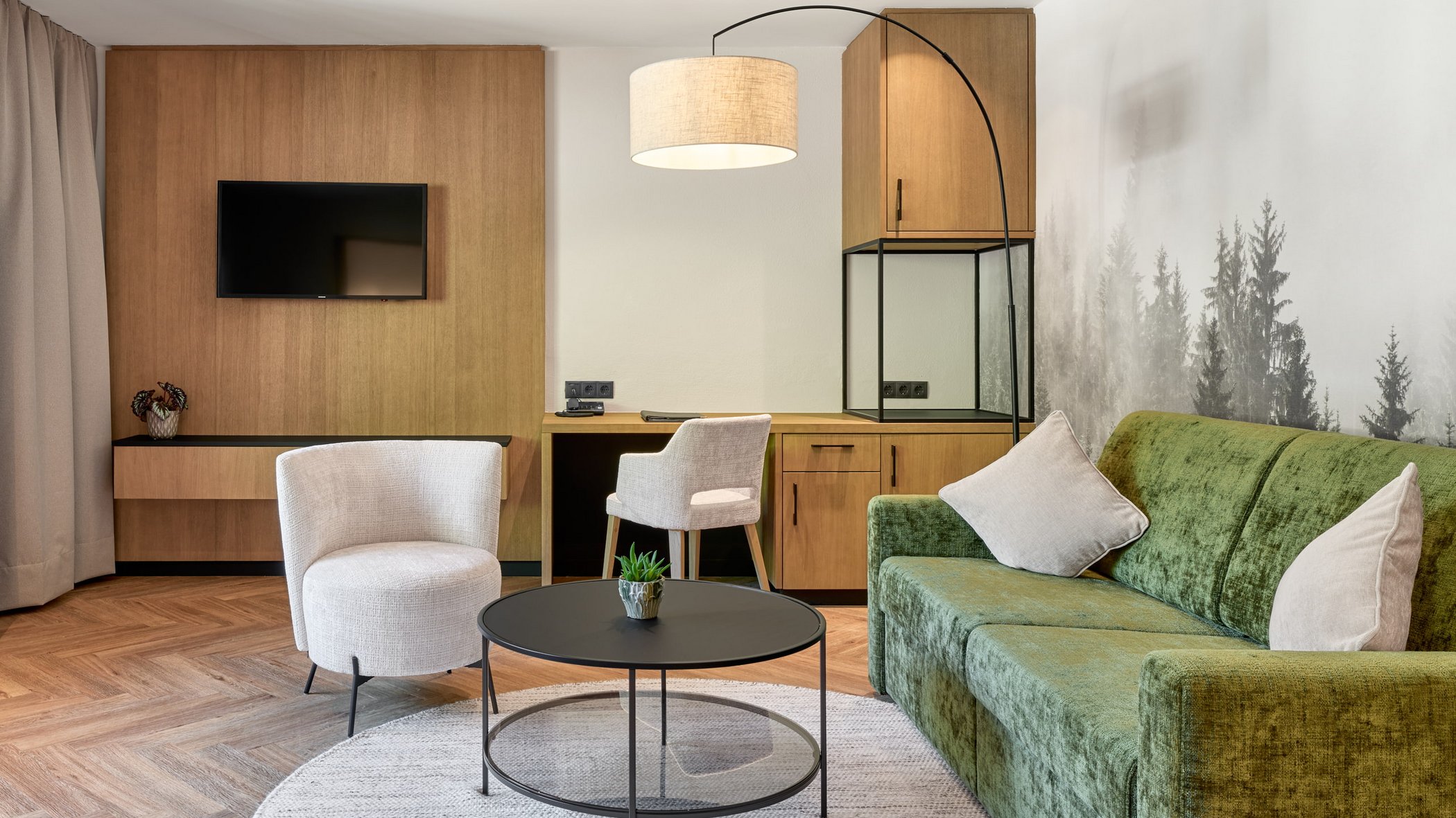 Stubaital: das Hotel mit Pool Modern eingerichtetes Wohnzimmer mit grünem Sofa, weißen Stühlen und Holzvertäfelung