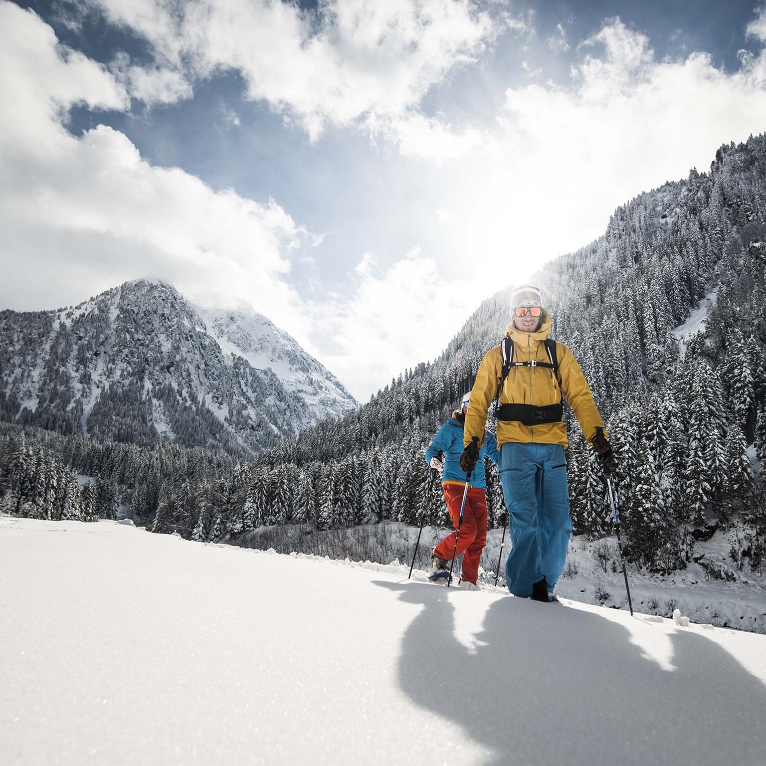 Stubaital: das Hotel mit Pool Zwei Personen beim Schneeschuhwandern in verschneiter Berglandschaft