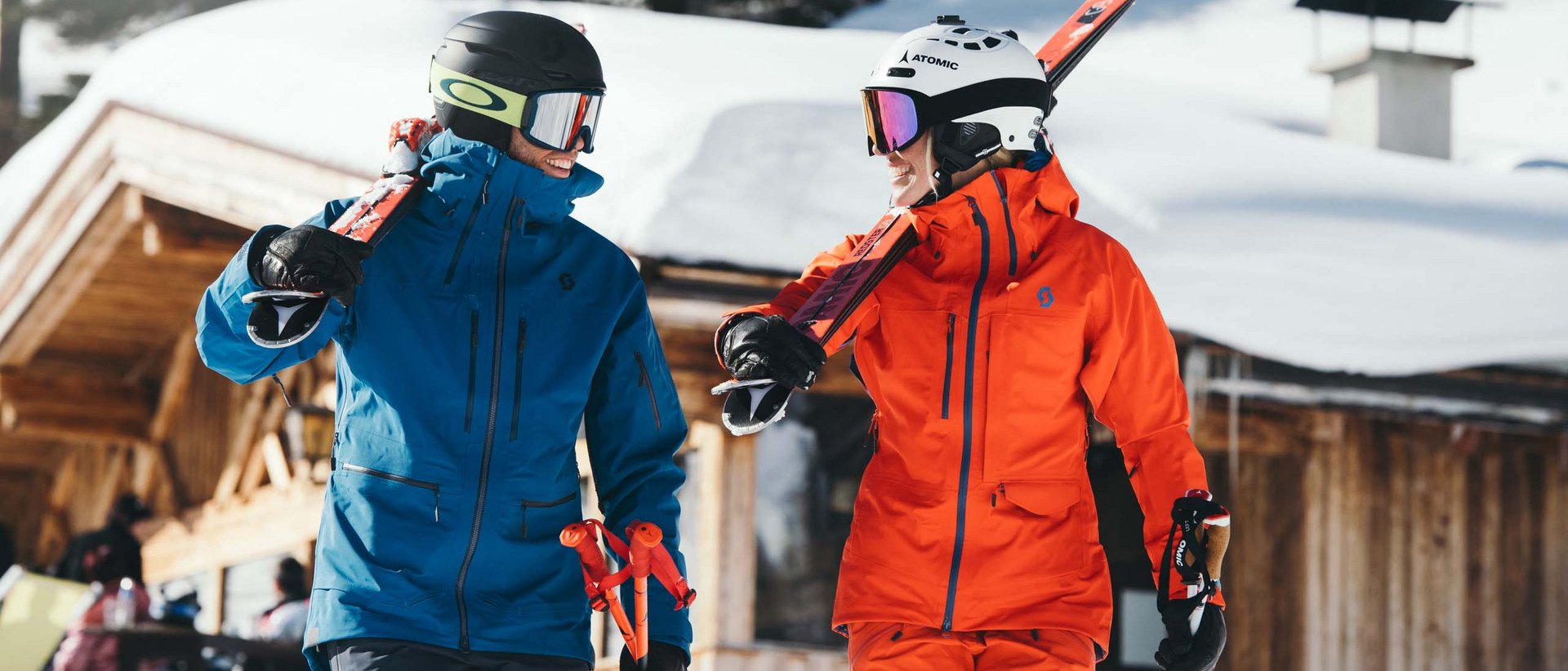 Unsere Neujahrsvorsätze Zwei Skifahrer in bunten Jacken tragen Skier auf der Schulter im Schnee