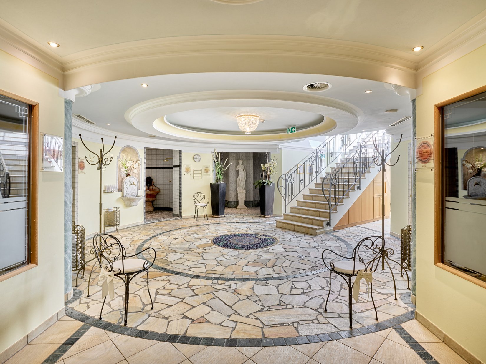 Stubaital: das Hotel mit Pool Heller Wellnessbereich mit Mosaiksteinboden, Treppe und Statuen