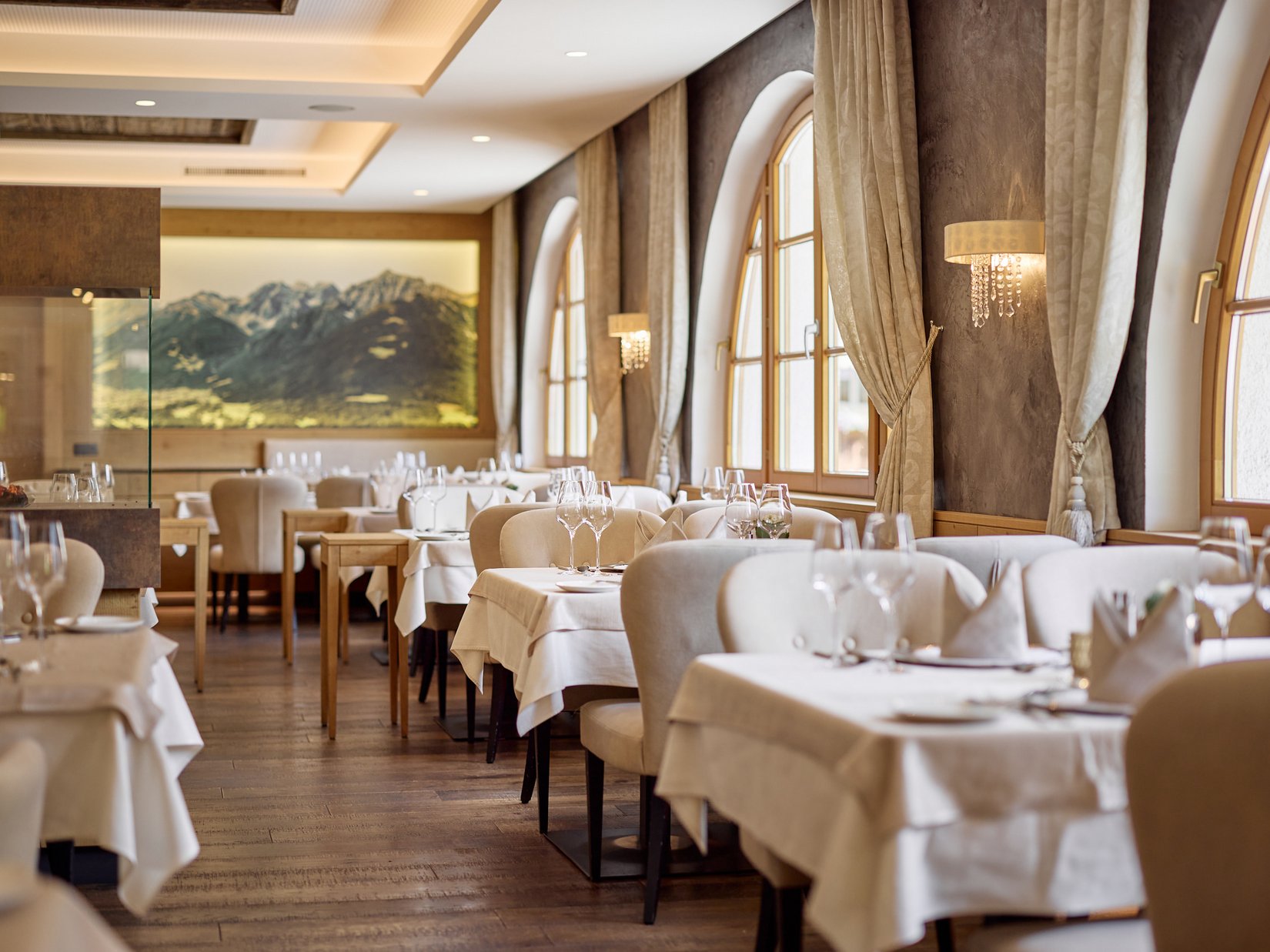 Stubai: l’hotel con piscina che cercavate è qui Ristorante elegante con tovaglie bianche e quadro di montagne alla parete