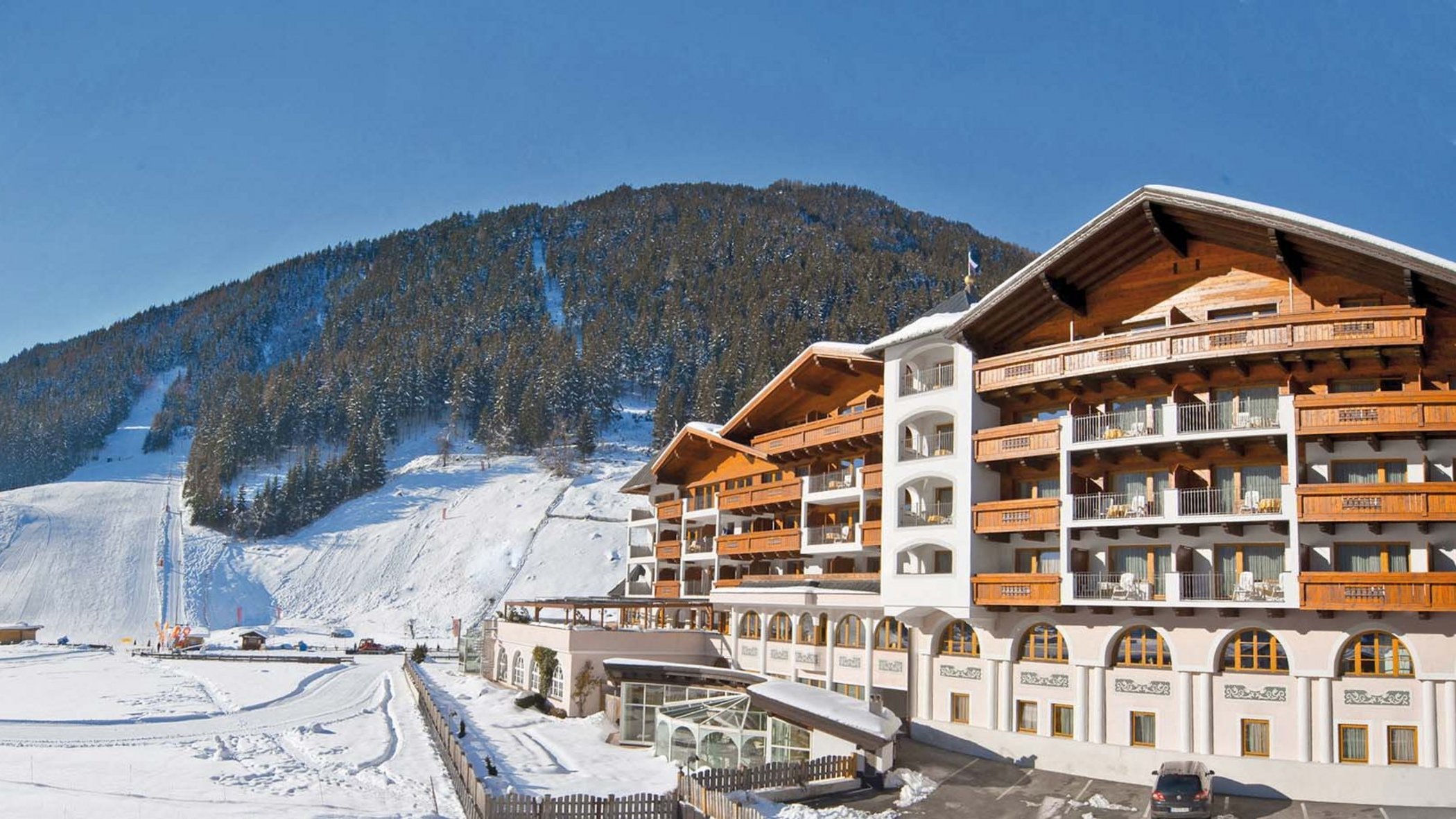 Stubaital: das Hotel mit Pool Sonniger Wintertag mit schneebedecktem Hotel und Berglandschaft