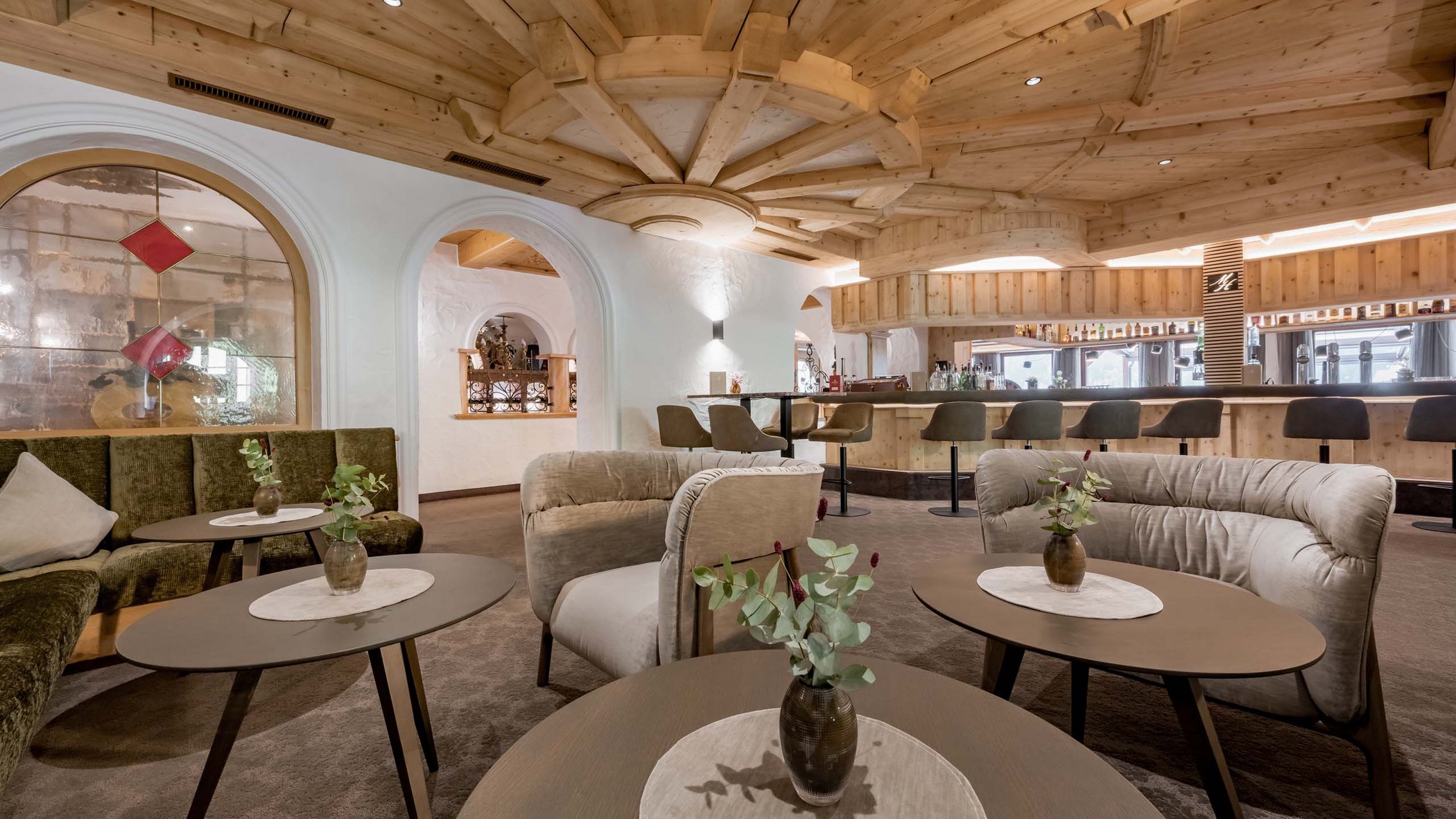 Stubaital: das Hotel mit Pool Gemütliche Hotelbar mit Holzdecke, Sofas und Tischen mit Vasen