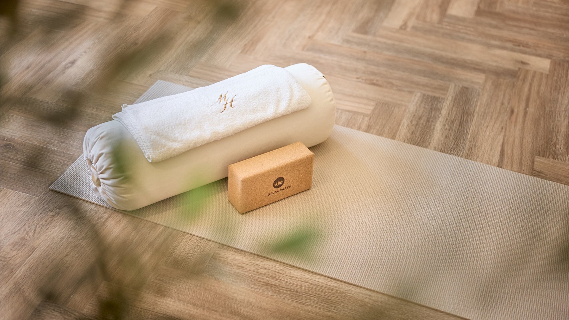 Stubaital: das Hotel mit Pool Yoga-Matte mit Yogakissen, Handtuch und Korkblock auf Holzfußboden